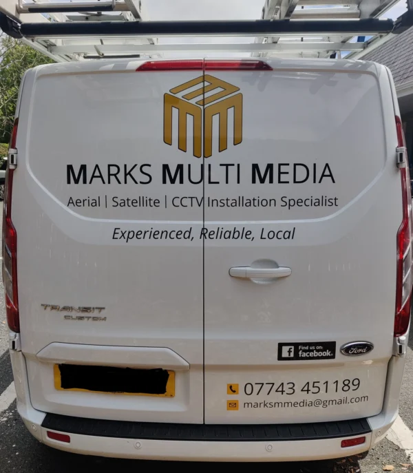 The back of a Marks Multi Media van displaying branding and contact details for aerial, satellite, and CCTV installation services.